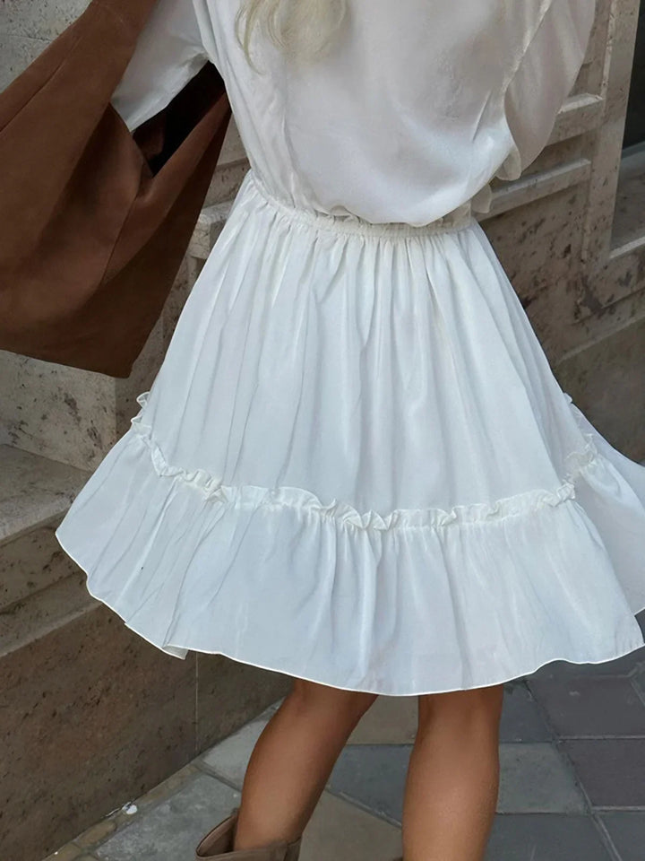 a little girl in a white dress is walking down the street