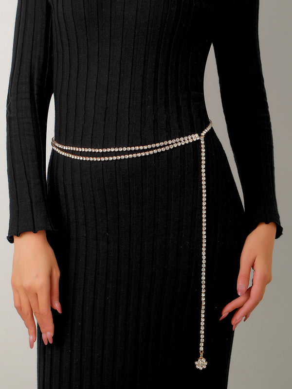 a woman in a black dress with a chain belt
