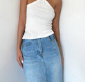 a woman wearing a white top and blue jeans