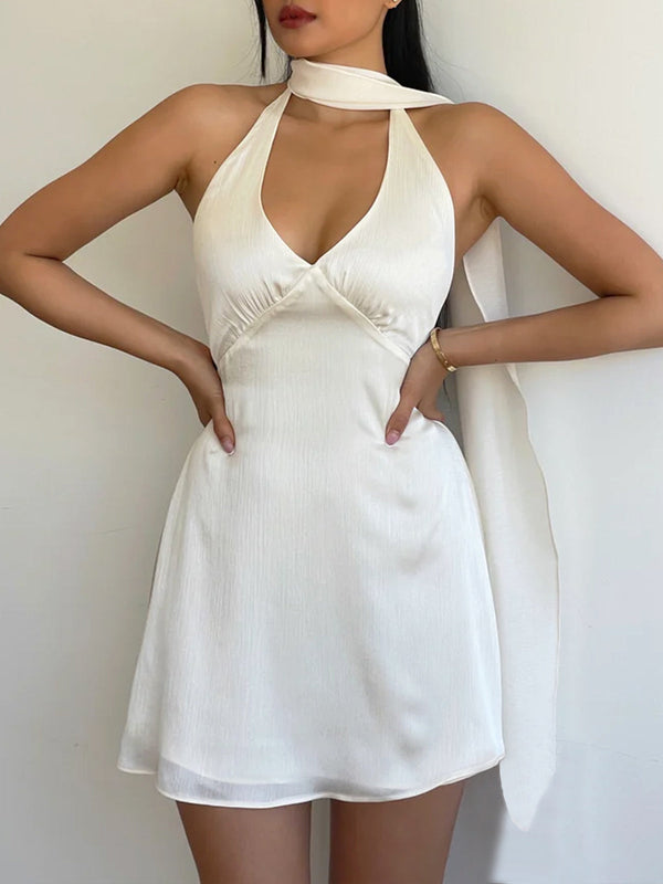 a woman wearing a white dress with a halt neck