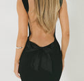 the back of a woman in a black dress