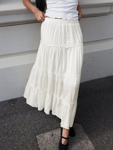 a woman wearing a white dress and black jacket