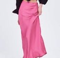 a woman in a black top and pink skirt