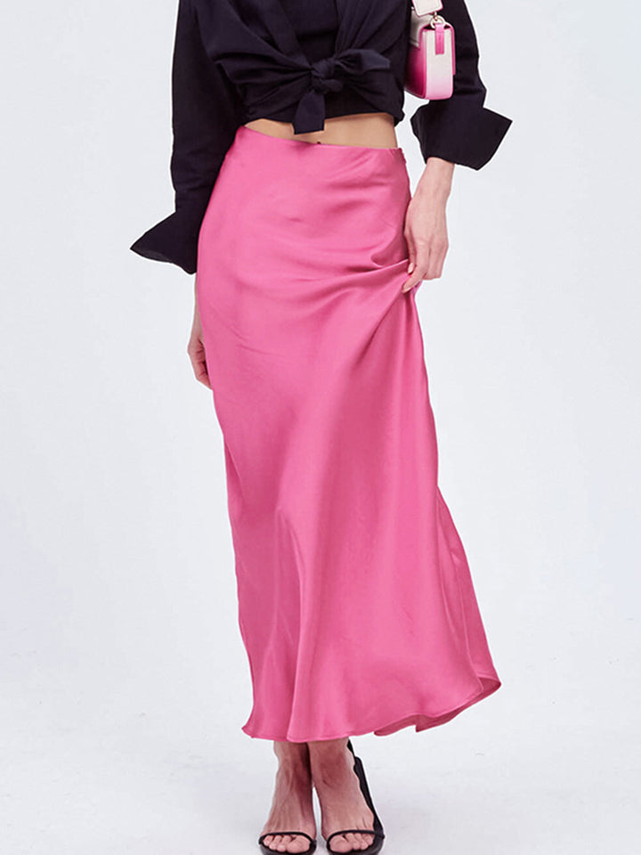 a woman in a black top and pink skirt