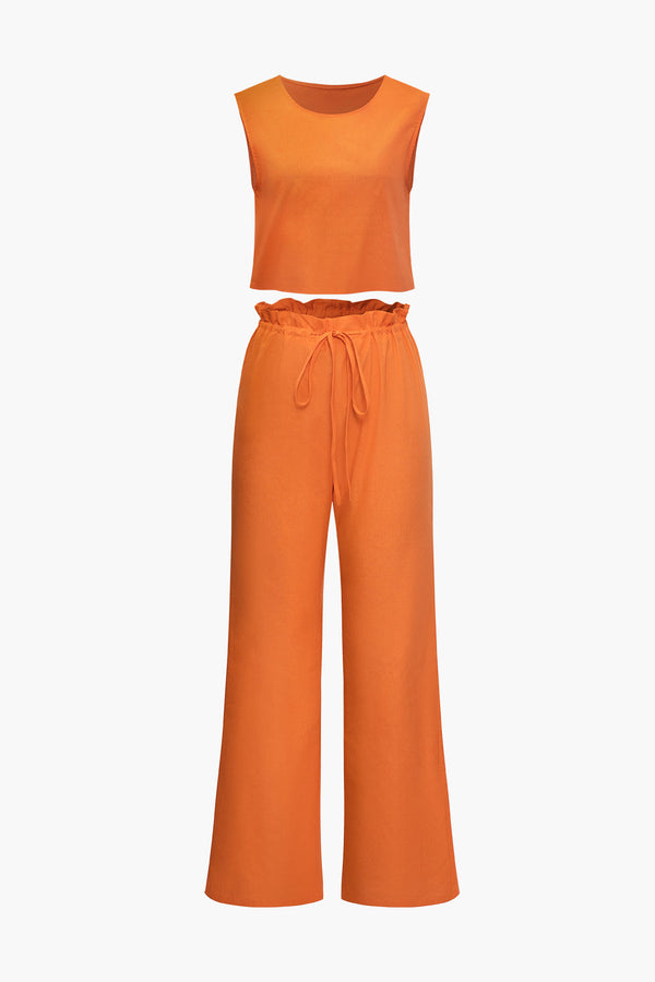 a woman is wearing an orange top and pants