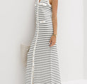 a woman wearing a white and black striped maxi dress