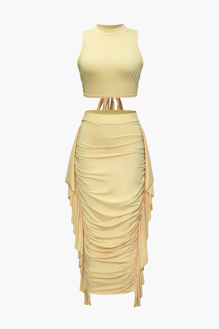 a woman wearing a yellow dress and a beige top