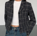 a woman wearing a black and white plaid jacket