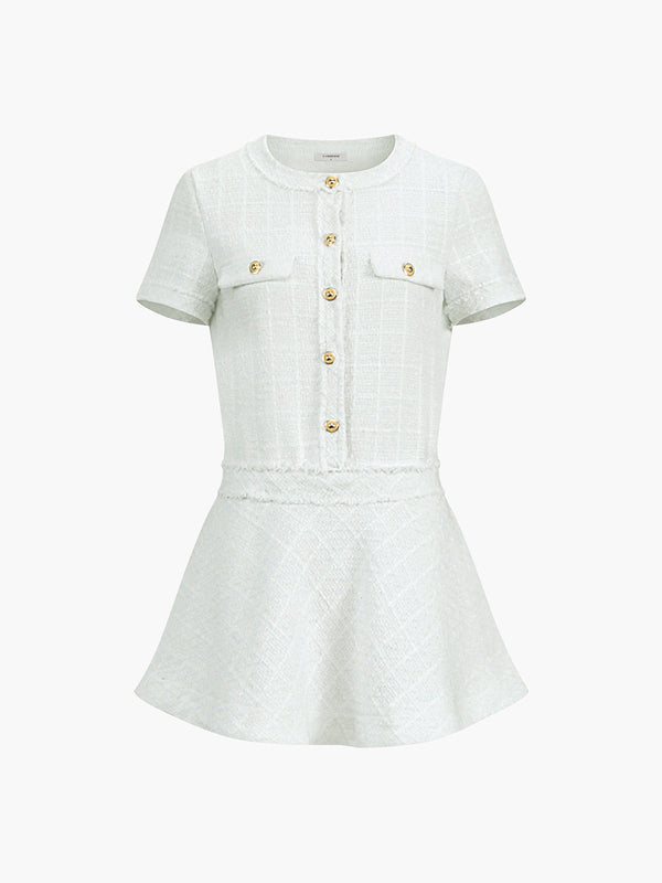 a white dress with a gold button on the front