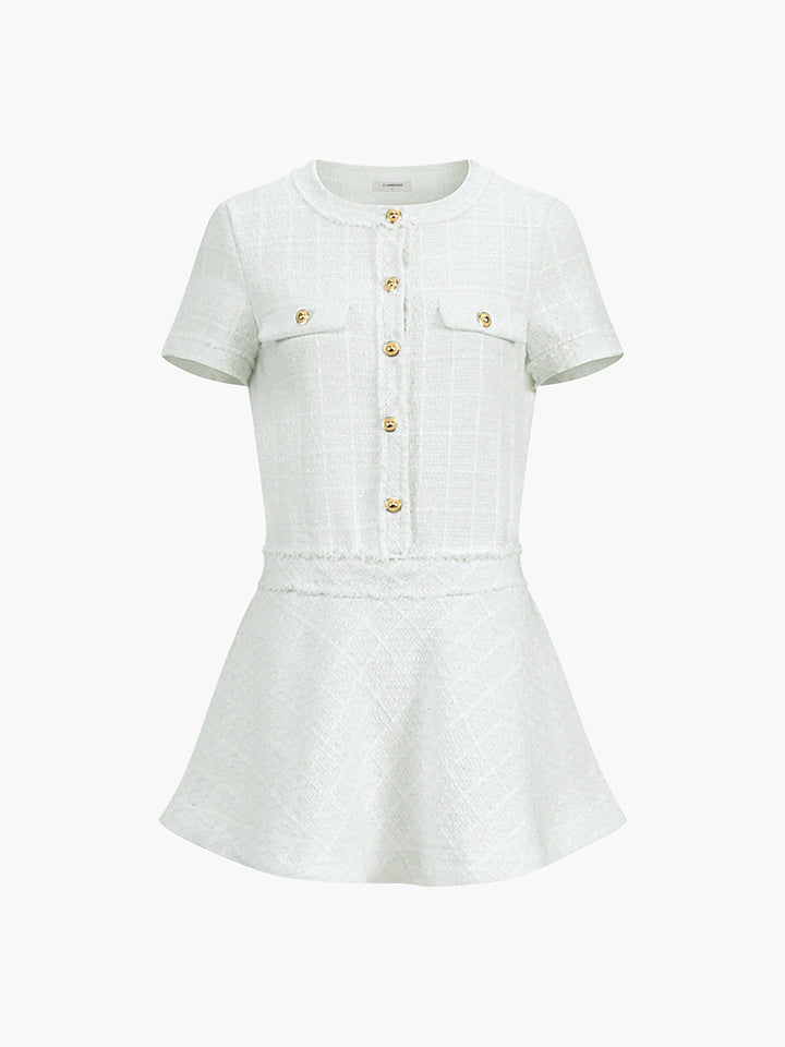 a white dress with a gold button on the front