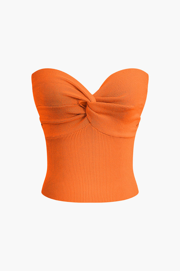 a woman wearing an orange top with a large bow