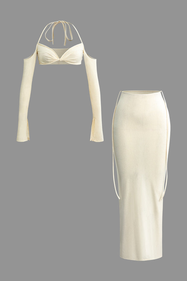 a white dress with long sleeves and a tie around the neck