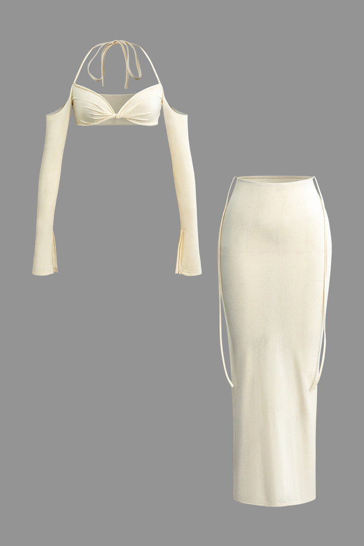 a white dress with long sleeves and a tie around the neck