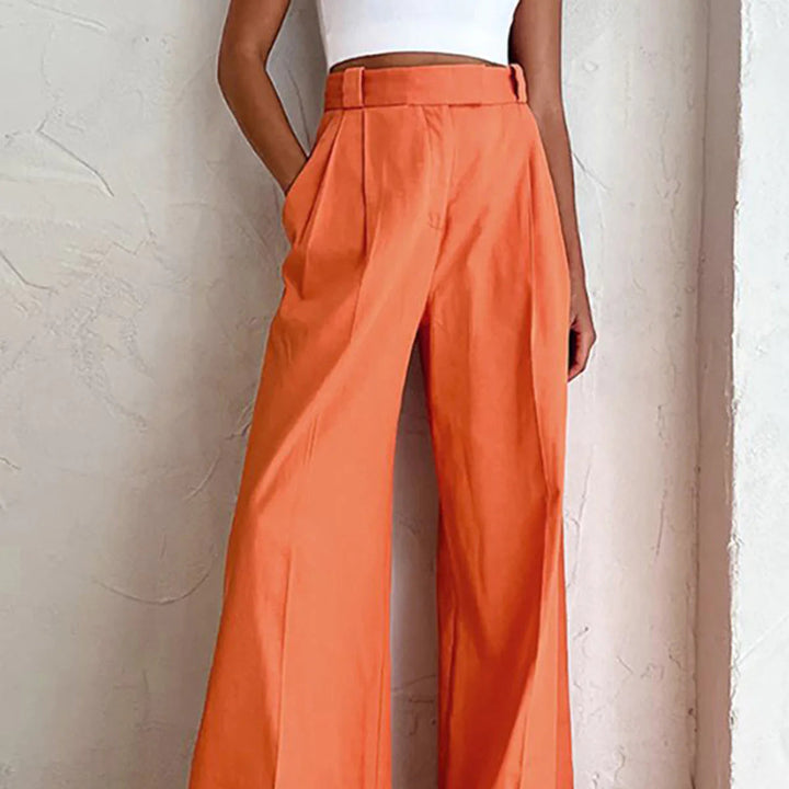 a woman in a white top and orange pants